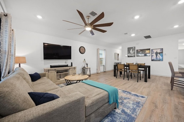 living room featuring ceiling fan, light wood-type flooring, and recessed lighting