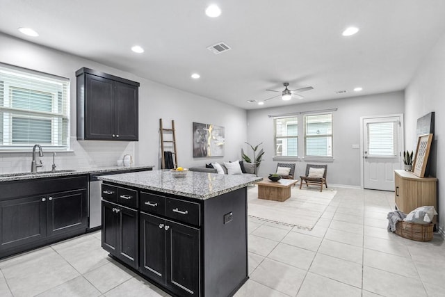 1808 Pecan Island Dr, Leander, TX 78641 - kitchen with a sink, dark cabinetry, ceiling fan, recessed lighting, and light tile patterned floors
