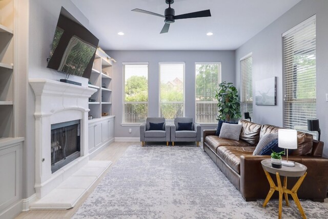 4207 Lazy River Bnd, Cedar Park, TX 78613 - living room with a ceiling fan, wood finished floors, a fireplace with raised hearth, recessed lighting, and built in shelves