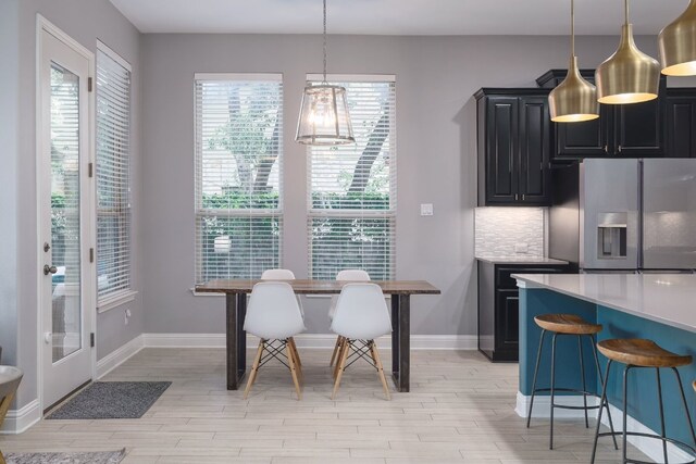 dining room featuring light wood-type flooring and baseboards