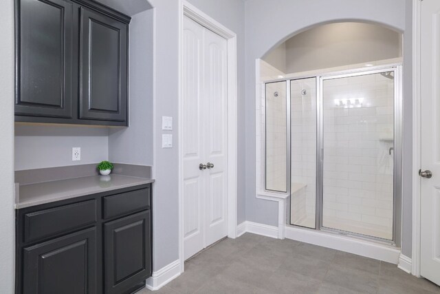 full bathroom with a stall shower and baseboards