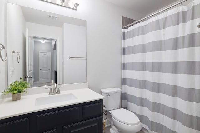 full bathroom featuring toilet, vanity, and curtained shower