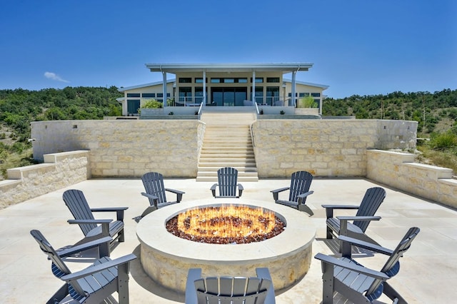 1785 Backbone Rdg, Wimberley, TX 78666 - view of patio featuring an outdoor fire pit, stairway, a sunroom, and a view of trees
