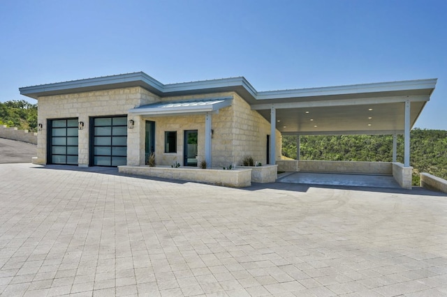 1785 Backbone Rdg, Wimberley, TX 78666 - contemporary home with an attached garage, decorative driveway, and stone siding