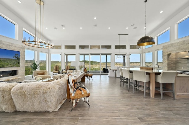 1785 Backbone Rdg, Wimberley, TX 78666 - living area with a chandelier, recessed lighting, a high end fireplace, wood finished floors, and a high ceiling