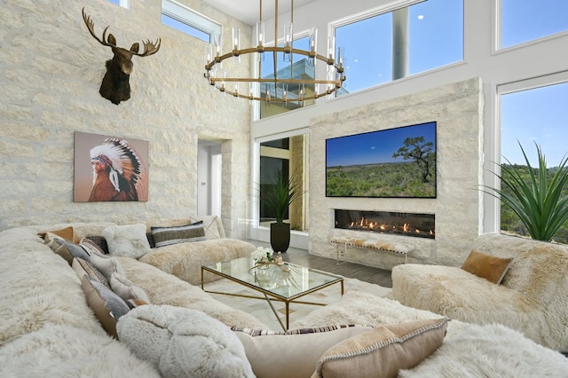 1785 Backbone Rdg, Wimberley, TX 78666 - living room with a towering ceiling, wood finished floors, a premium fireplace, and a chandelier