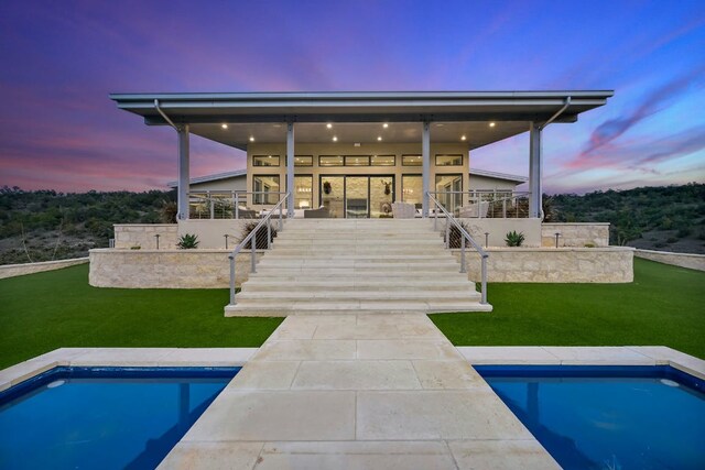 1785 Backbone Rdg, Wimberley, TX 78666 - back of property at dusk featuring stairway, an outdoor pool, and a yard
