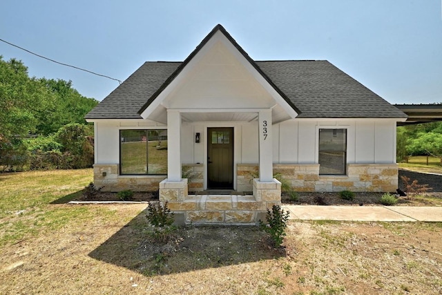 337 Forest Lake Dr, Del Valle, TX 78617 - modern farmhouse with stone siding, roof with shingles, board and batten siding, and a porch