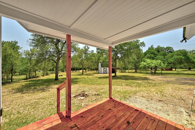 337 Forest Lake Dr, Del Valle, TX 78617 - wooden deck with a storage shed, view of scattered trees, and a yard