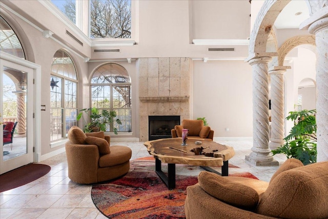 2604 Saratoga Dr, Austin, TX 78733 - living area with decorative columns, plenty of natural light, a towering ceiling, and a tile fireplace