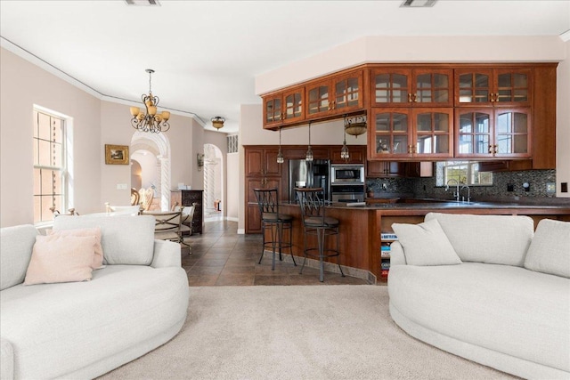 2604 Saratoga Dr, Austin, TX 78733 - living room featuring arched walkways, tile patterned flooring, a chandelier, and crown molding