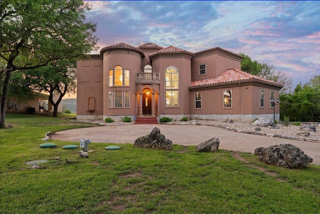 2604 Saratoga Dr, Austin, TX 78733 - mediterranean / spanish home with curved driveway, a yard, stucco siding, and a tiled roof