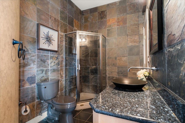 2604 Saratoga Dr, Austin, TX 78733 - bathroom with tile walls, vanity, toilet, a shower stall, and tile patterned flooring