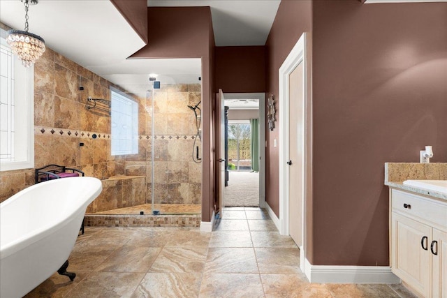 2604 Saratoga Dr, Austin, TX 78733 - full bath featuring a freestanding bath, a stall shower, vanity, a chandelier, and baseboards