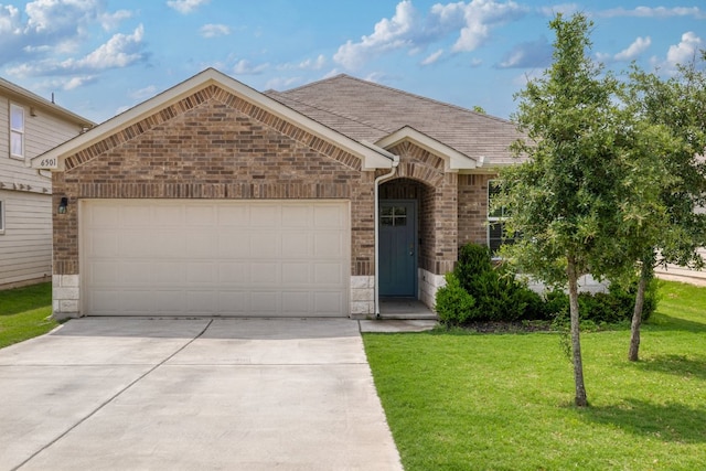 view of front of home with an attached garage, driveway, a front lawn, brick siding, and stone siding