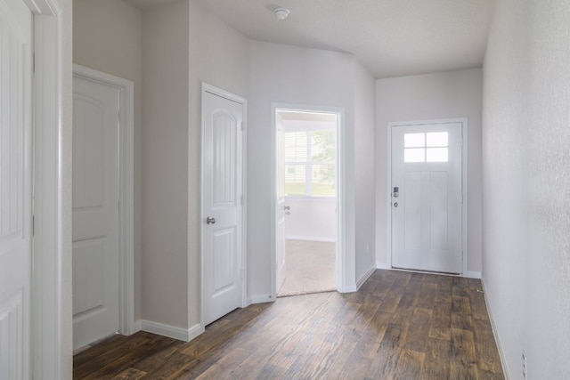 foyer entrance featuring dark wood-style floors and baseboards