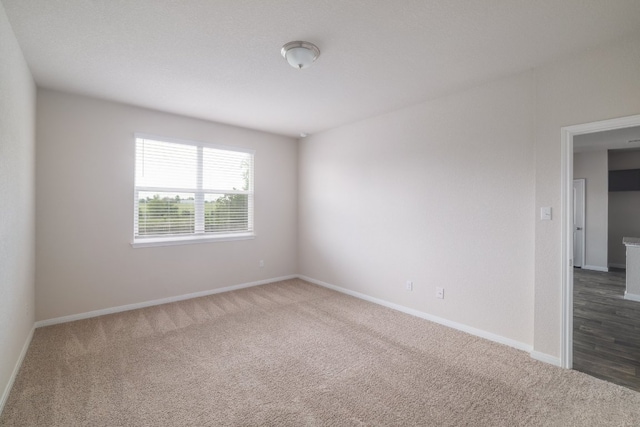 empty room featuring carpet flooring and baseboards