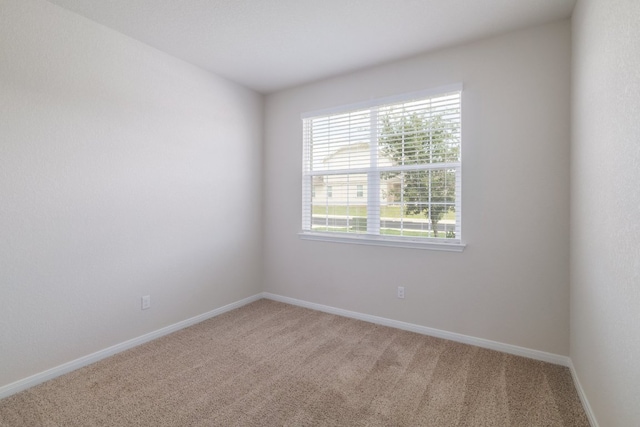 carpeted empty room featuring healthy amount of natural light and baseboards
