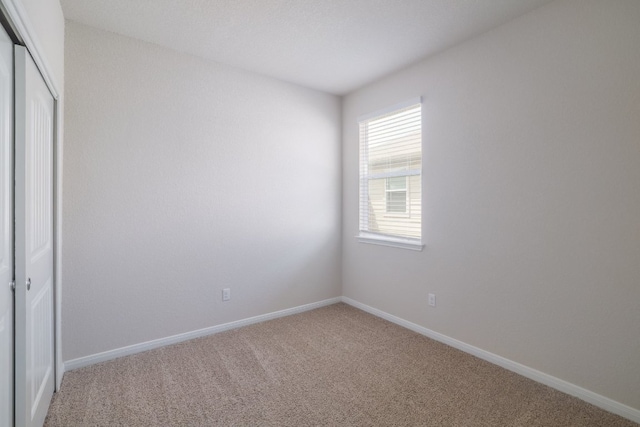 unfurnished bedroom with carpet flooring, a closet, and baseboards