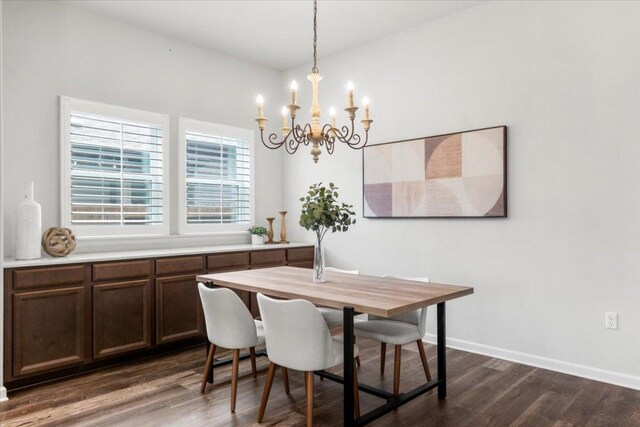 dining area featuring a chandelier, dark wood-style floors, and baseboards