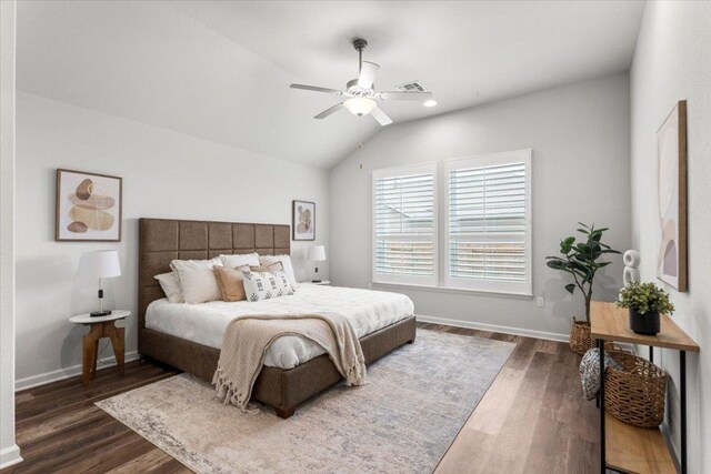bedroom with dark wood-style floors, vaulted ceiling, baseboards, and ceiling fan