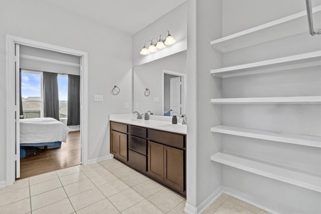 518 Algaroba Loop, Buda, TX 78610 - ensuite bathroom featuring double vanity, tile patterned flooring, and baseboards