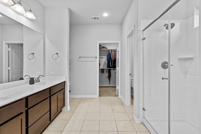 518 Algaroba Loop, Buda, TX 78610 - full bath with a stall shower, a walk in closet, double vanity, and tile patterned floors