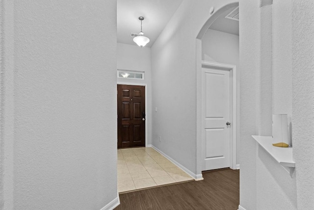 518 Algaroba Loop, Buda, TX 78610 - entrance foyer featuring arched walkways, a textured wall, wood finished floors, and baseboards