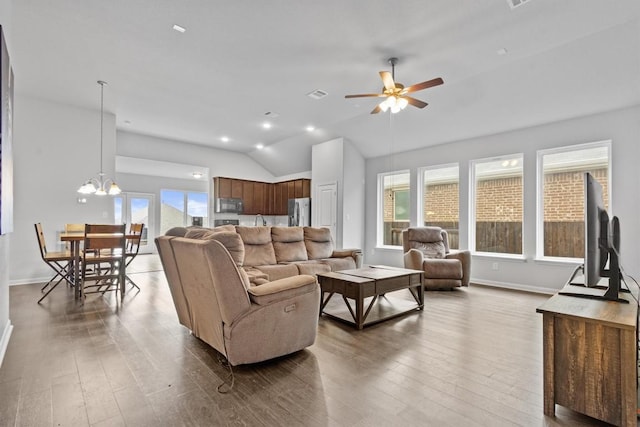 518 Algaroba Loop, Buda, TX 78610 - living area with ceiling fan, wood finished floors, vaulted ceiling, baseboards, and a chandelier
