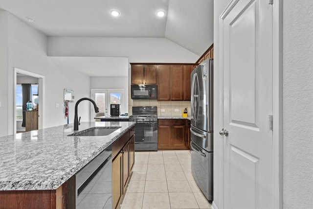 518 Algaroba Loop, Buda, TX 78610 - kitchen with stainless steel appliances, a sink, lofted ceiling, decorative backsplash, and light stone countertops