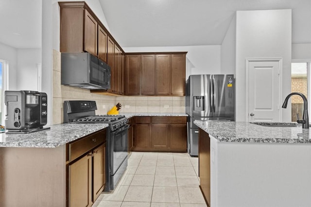 518 Algaroba Loop, Buda, TX 78610 - kitchen featuring black appliances, backsplash, light tile patterned floors, light stone counters, and a sink