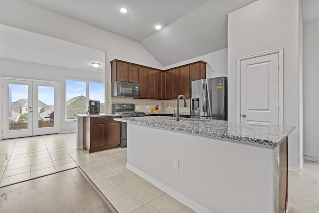 518 Algaroba Loop, Buda, TX 78610 - kitchen featuring stainless steel fridge, gas range oven, black microwave, a sink, and lofted ceiling