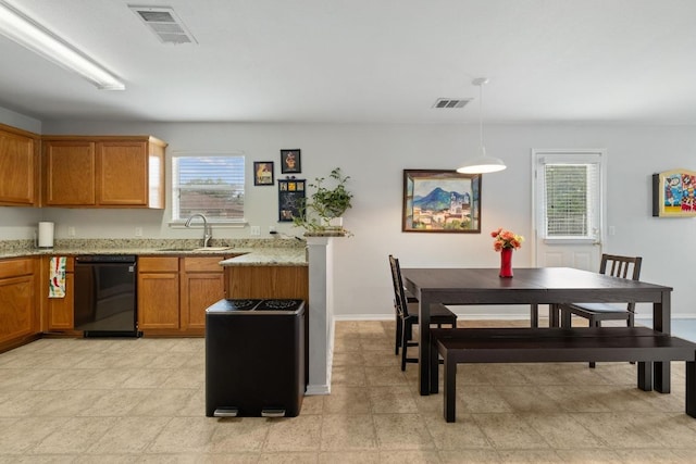 1320 Anna Palm Way, Round Rock, TX 78665 - kitchen with black dishwasher, brown cabinetry, plenty of natural light, and light stone counters