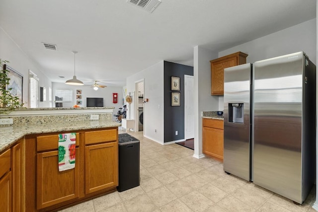1320 Anna Palm Way, Round Rock, TX 78665 - kitchen featuring stainless steel fridge, brown cabinets, ceiling fan, open floor plan, and light stone countertops