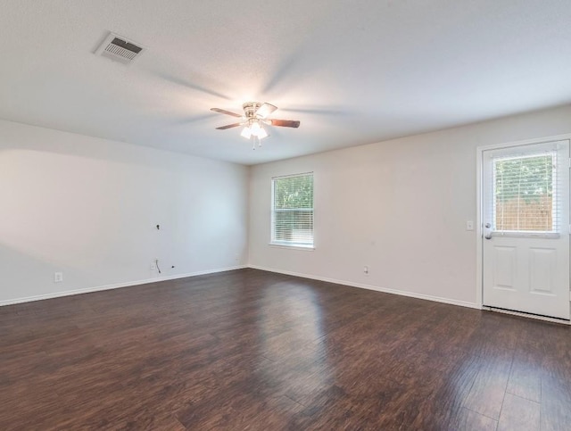 131 Ames Cv, Kyle, TX 78640 - spare room with a ceiling fan, plenty of natural light, dark wood finished floors, and baseboards