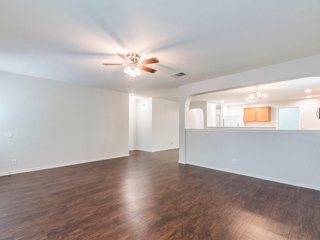 131 Ames Cv, Kyle, TX 78640 - unfurnished living room with a ceiling fan, dark wood-style flooring, arched walkways, a chandelier, and baseboards
