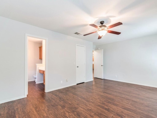 131 Ames Cv, Kyle, TX 78640 - unfurnished bedroom with dark wood-style flooring, baseboards, and ensuite bathroom