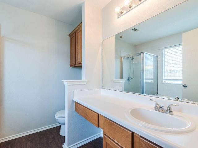 131 Ames Cv, Kyle, TX 78640 - bathroom featuring a shower stall, toilet, wood finished floors, vanity, and baseboards