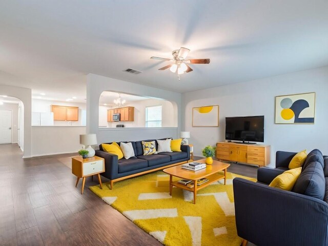 131 Ames Cv, Kyle, TX 78640 - living area featuring a ceiling fan, arched walkways, dark wood finished floors, and a chandelier