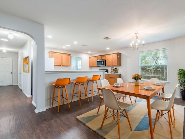 131 Ames Cv, Kyle, TX 78640 - dining room featuring dark wood-type flooring, a chandelier, arched walkways, baseboards, and recessed lighting