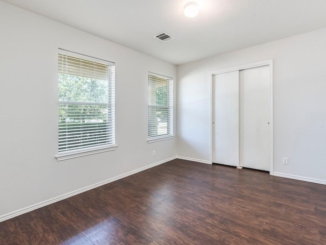 131 Ames Cv, Kyle, TX 78640 - unfurnished bedroom featuring dark wood-type flooring, baseboards, and a closet