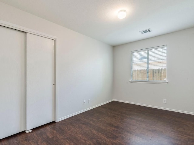 131 Ames Cv, Kyle, TX 78640 - unfurnished bedroom with wood finished floors, baseboards, and a closet