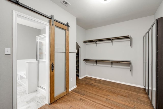 205 Talon Grasp Trl, Leander, TX 78641 - spacious closet featuring a barn door and light wood-style flooring