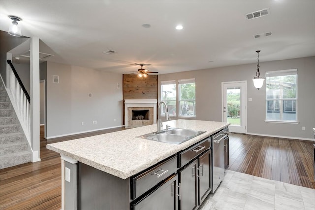 205 Talon Grasp Trl, Leander, TX 78641 - kitchen featuring a sink, dishwasher, a ceiling fan, a fireplace, and open floor plan