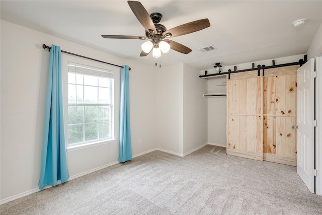 205 Talon Grasp Trl, Leander, TX 78641 - unfurnished bedroom featuring carpet floors, a barn door, ceiling fan, and a closet