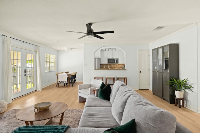 2812 Sissinghurst Dr, Austin, TX 78745 - living area featuring french doors, light wood-style floors, a ceiling fan, and baseboards
