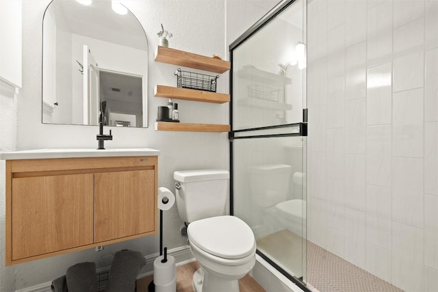 2812 Sissinghurst Dr, Austin, TX 78745 - full bathroom featuring toilet, a stall shower, wood finished floors, and vanity