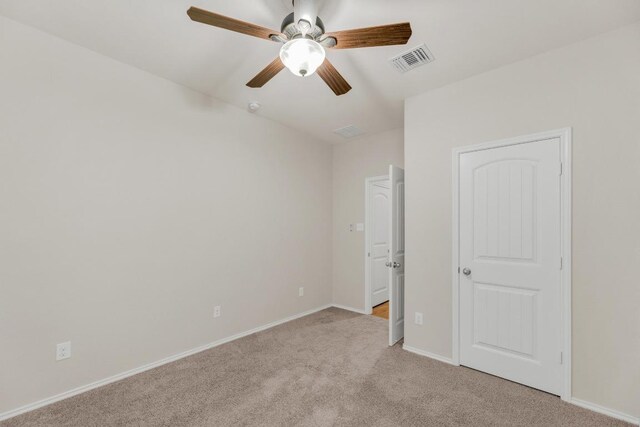 unfurnished bedroom featuring light colored carpet, baseboards, and a ceiling fan