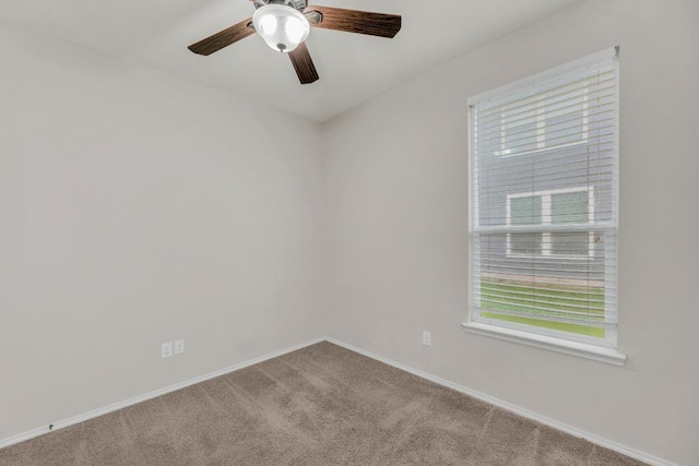 carpeted spare room with baseboards and a ceiling fan