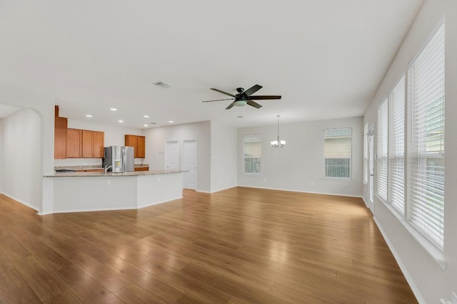 5928 Pescia St, Round Rock, TX 78665 - unfurnished living room with ceiling fan, a chandelier, wood finished floors, and recessed lighting